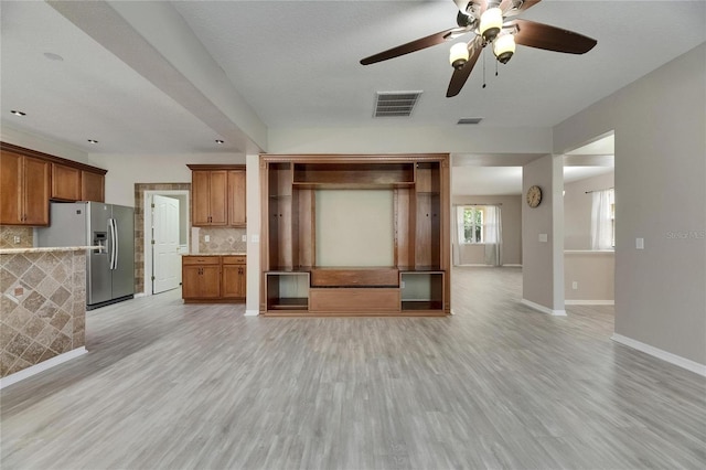 unfurnished living room featuring light wood-style floors, baseboards, and ceiling fan