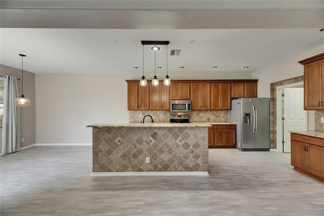 kitchen featuring appliances with stainless steel finishes, decorative backsplash, brown cabinetry, and baseboards