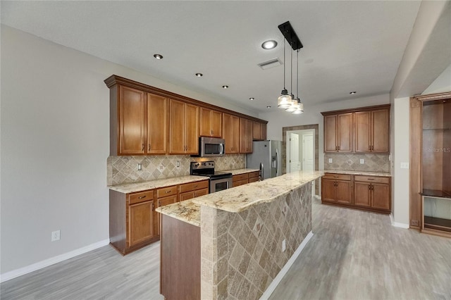 kitchen featuring appliances with stainless steel finishes, brown cabinetry, light wood-type flooring, baseboards, and recessed lighting