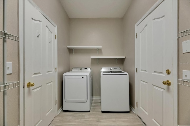 laundry area with light wood finished floors, separate washer and dryer, and baseboards