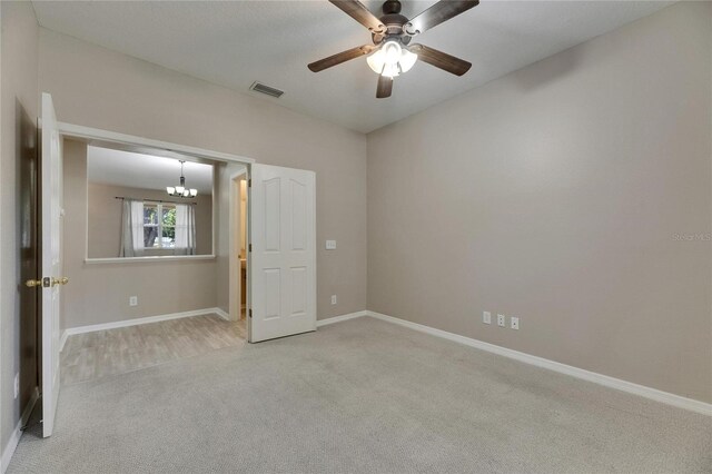 unfurnished bedroom with carpet floors, a chandelier, baseboards, and ceiling fan