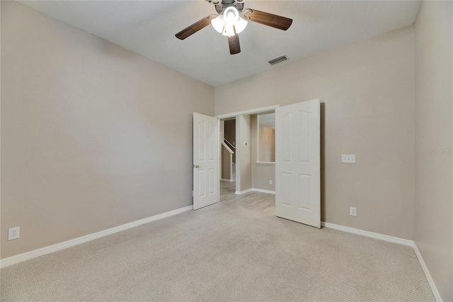 unfurnished bedroom with light carpet, baseboards, and a ceiling fan
