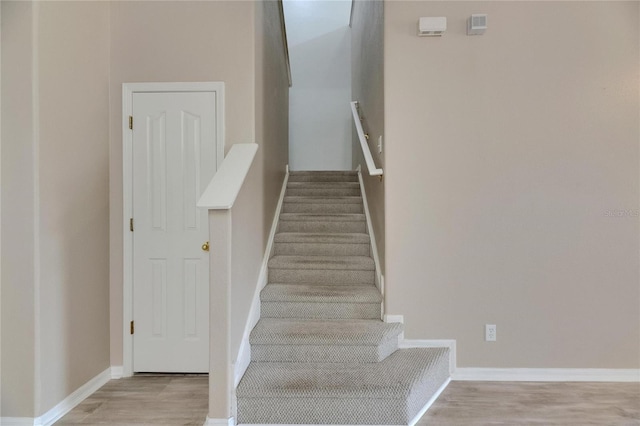 stairs with wood finished floors and baseboards