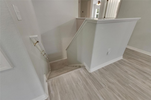 stairway featuring wood finished floors and baseboards