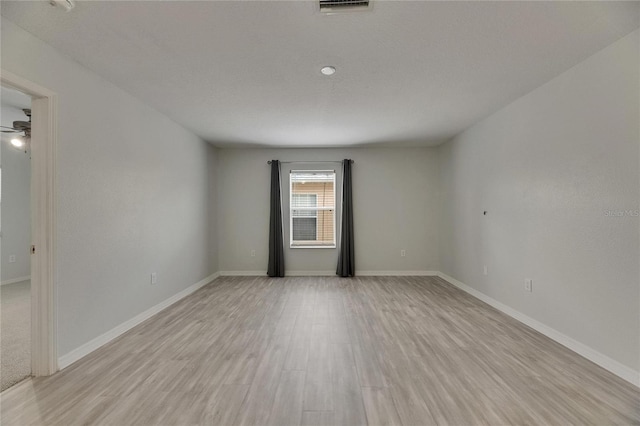 spare room with light wood-type flooring and baseboards