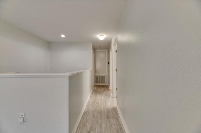 corridor with baseboards, light wood-style flooring, and recessed lighting