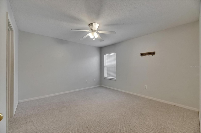 carpeted spare room featuring a ceiling fan, baseboards, and a textured ceiling