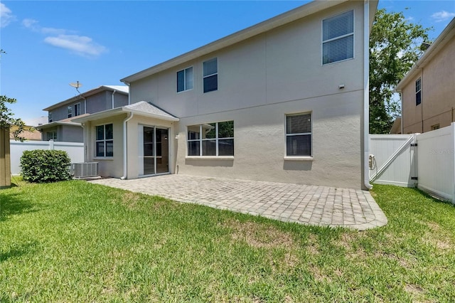 back of house featuring a patio area, a gate, stucco siding, and central air condition unit