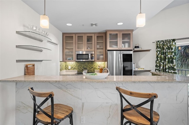 1010 Central Ave Unit 227, Saint Petersburg, FL 33705 - kitchen with stainless steel appliances, backsplash, a kitchen breakfast bar, light stone countertops, and recessed lighting