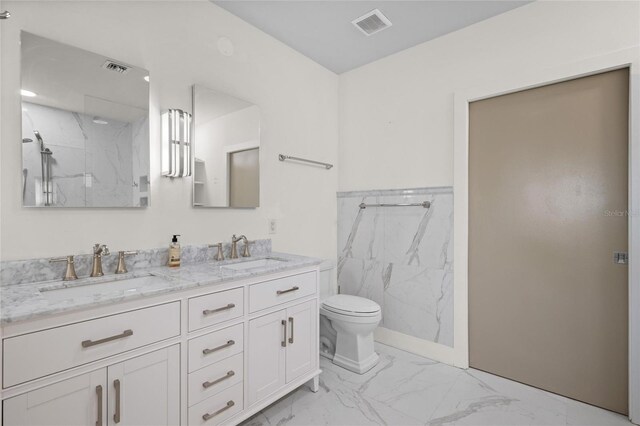 1010 Central Ave Unit 227, Saint Petersburg, FL 33705 - bathroom with toilet, marble look tiles, double vanity, and a marble finish shower
