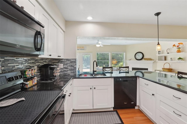 71 Flamingo Cir, Safety Harbor, FL 34695 - kitchen featuring black appliances, a sink, a ceiling fan, dark countertops, and tasteful backsplash