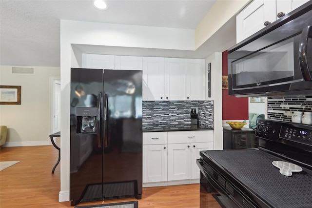 71 Flamingo Cir, Safety Harbor, FL 34695 - kitchen featuring black appliances, white cabinets, dark countertops, tasteful backsplash, and baseboards