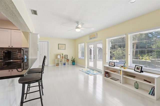 71 Flamingo Cir, Safety Harbor, FL 34695 - kitchen featuring a ceiling fan, a sink, decorative backsplash, wood finished floors, and a kitchen bar