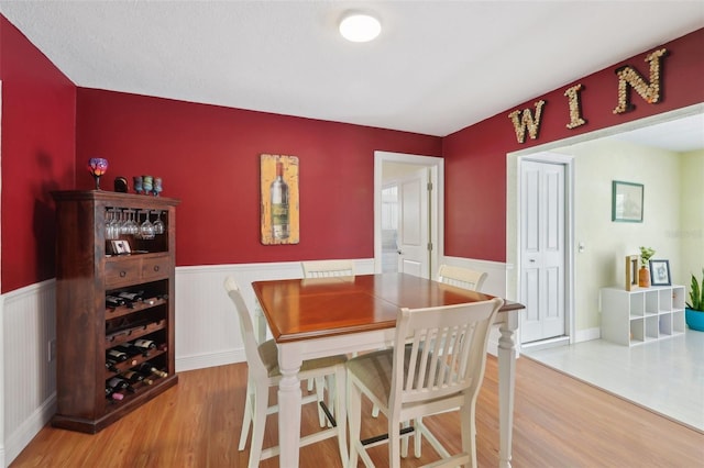 71 Flamingo Cir, Safety Harbor, FL 34695 - dining space featuring light wood-style flooring and a wainscoted wall