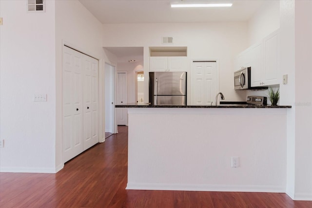 18107 Peregrines Perch Pl Unit 6303, Lutz, FL 33558 - kitchen featuring stainless steel appliances, a peninsula, white cabinets, dark wood-style flooring, and baseboards