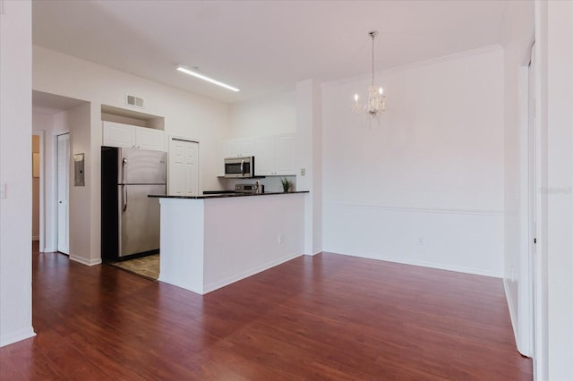 18107 Peregrines Perch Pl Unit 6303, Lutz, FL 33558 - kitchen with appliances with stainless steel finishes, white cabinetry, dark countertops, a chandelier, and dark wood-style flooring