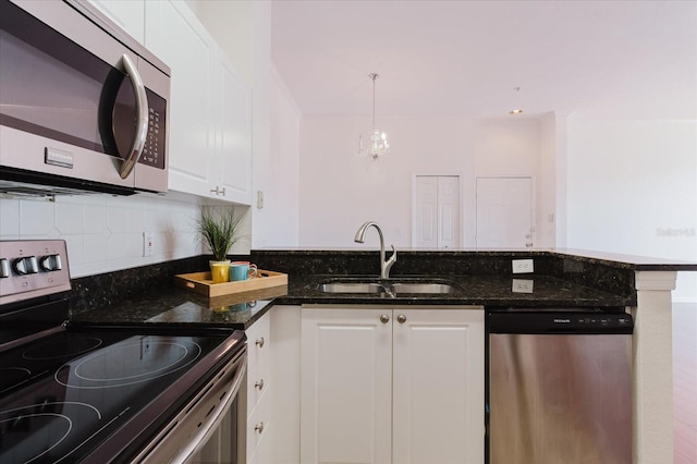 18107 Peregrines Perch Pl Unit 6303, Lutz, FL 33558 - kitchen with stainless steel appliances, a sink, a peninsula, white cabinets, and tasteful backsplash