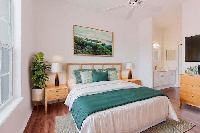 18107 Peregrines Perch Pl Unit 6303, Lutz, FL 33558 - bedroom with wood finished floors, ensuite bath, baseboards, a sink, and a ceiling fan