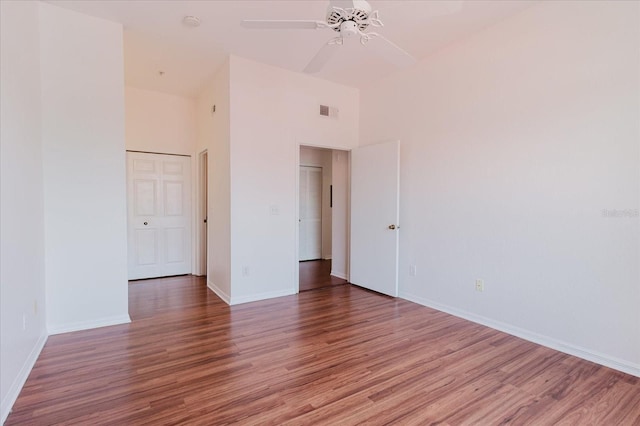 18107 Peregrines Perch Pl Unit 6303, Lutz, FL 33558 - spare room featuring wood finished floors, a ceiling fan, baseboards, and a high ceiling