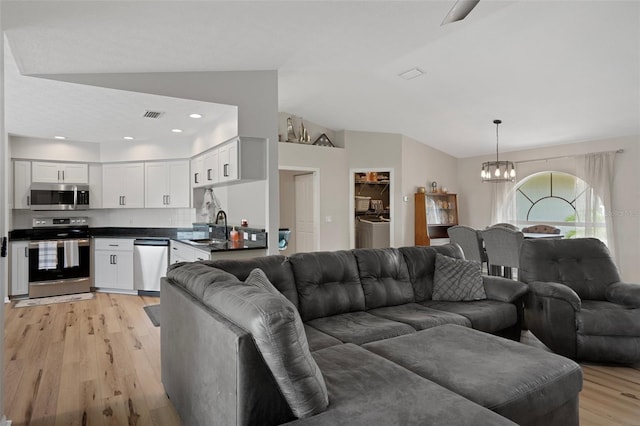 1854 S Overview Dr, Lecanto, FL 34461 - living room featuring light wood-style flooring, a chandelier, vaulted ceiling, and recessed lighting