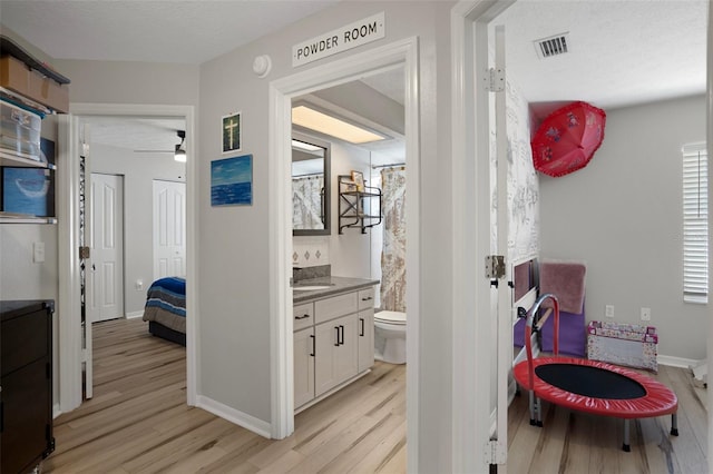 1854 S Overview Dr, Lecanto, FL 34461 - hallway with light wood finished floors, a sink, a textured ceiling, and baseboards