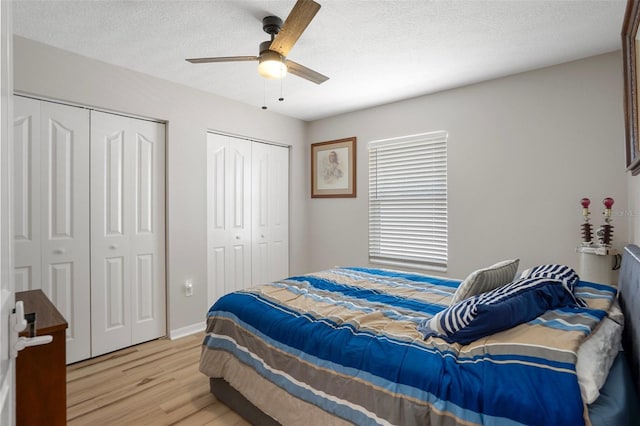 1854 S Overview Dr, Lecanto, FL 34461 - bedroom with two closets, light wood finished floors, a ceiling fan, and a textured ceiling
