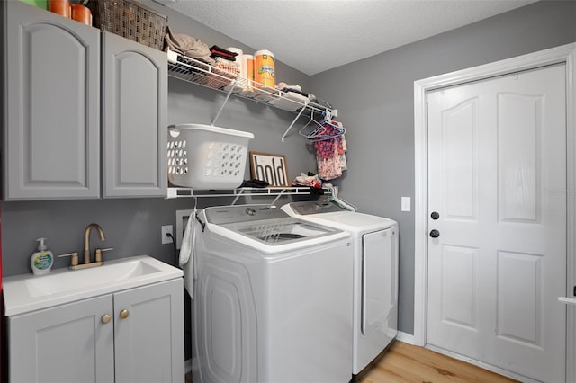 1854 S Overview Dr, Lecanto, FL 34461 - washroom with independent washer and dryer, cabinet space, light wood-style floors, and a textured ceiling