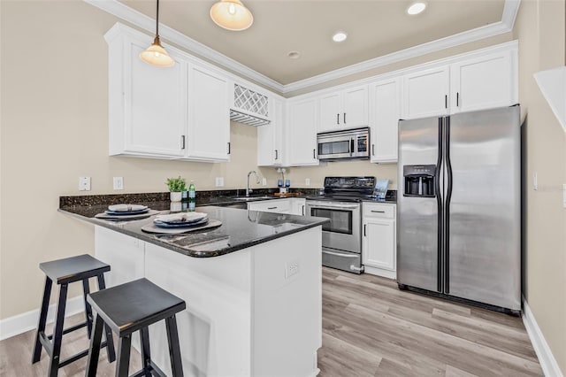 215 S Westland Ave Unit 3, Tampa, FL 33606 - kitchen featuring stainless steel appliances, a peninsula, white cabinets, crown molding, and light wood finished floors