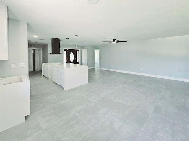 20295 Lorenzo Ave, Port Charlotte, FL 33952 - unfurnished living room featuring a ceiling fan, light tile patterned floors, and baseboards