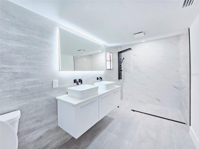 20295 Lorenzo Ave, Port Charlotte, FL 33952 - full bathroom featuring toilet, tile walls, a marble finish shower, and double vanity