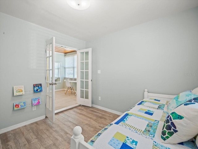 4005 W Coachman Ave, Tampa, FL 33611 - bedroom featuring french doors, wood finished floors, and baseboards