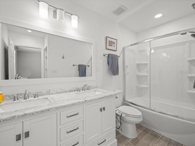 4005 W Coachman Ave, Tampa, FL 33611 - bathroom featuring wood finished floors, double vanity, toilet, shower / bath combination with glass door, and recessed lighting