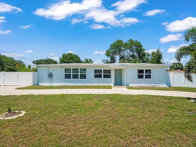 4005 W Coachman Ave, Tampa, FL 33611 - view of front of home with a gate, stucco siding, and decorative driveway