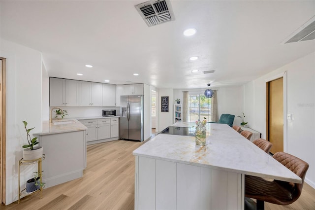 525 Gornto Lake Rd, Brandon, FL 33510 - kitchen featuring stainless steel appliances, a sink, a breakfast bar, light wood-type flooring, and recessed lighting