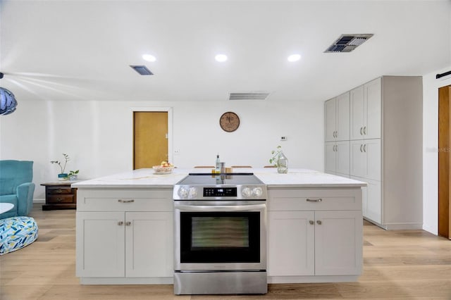 525 Gornto Lake Rd, Brandon, FL 33510 - kitchen with stainless steel range with electric stovetop, light wood-type flooring, light stone countertops, an island with sink, and recessed lighting
