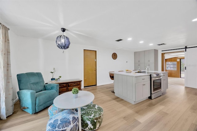 525 Gornto Lake Rd, Brandon, FL 33510 - kitchen with electric stove, light wood-style floors, recessed lighting, light countertops, and a center island with sink