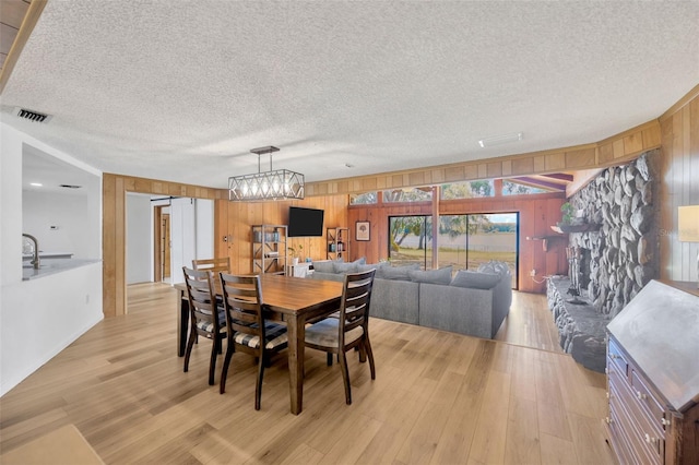 525 Gornto Lake Rd, Brandon, FL 33510 - dining area featuring wooden walls, light wood finished floors, a textured ceiling, and a chandelier