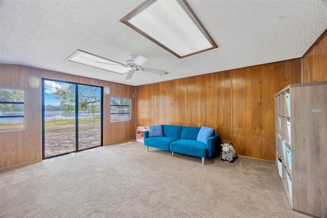 525 Gornto Lake Rd, Brandon, FL 33510 - living area with a textured ceiling, wooden walls, carpet floors, and a ceiling fan