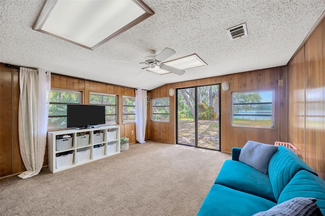 525 Gornto Lake Rd, Brandon, FL 33510 - carpeted living room featuring wooden walls, a textured ceiling, ceiling fan, and lofted ceiling