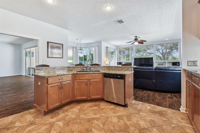 13028 Prestwick Dr, Riverview, FL 33579 - kitchen with stainless steel dishwasher, a sink, open floor plan, brown cabinets, and light wood finished floors