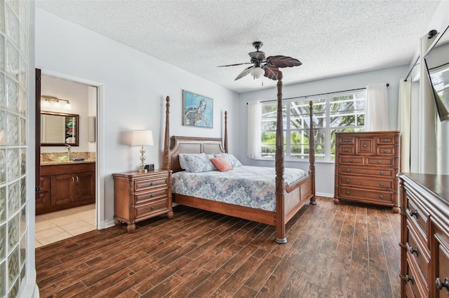 13028 Prestwick Dr, Riverview, FL 33579 - bedroom featuring dark wood finished floors, a textured ceiling, a sink, connected bathroom, and baseboards