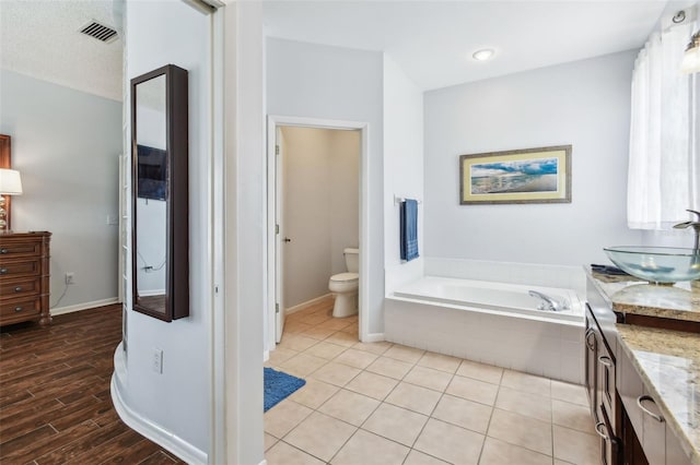 13028 Prestwick Dr, Riverview, FL 33579 - full bathroom featuring vanity, a bath, toilet, and baseboards