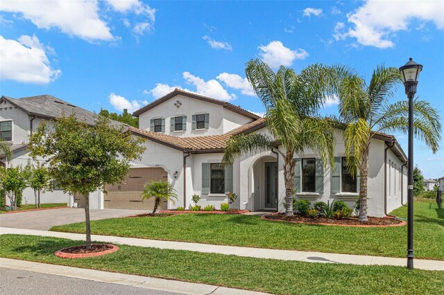6154 Marsh Trail Dr, Odessa, FL 33556 - mediterranean / spanish-style house featuring stucco siding, driveway, a front yard, and a garage