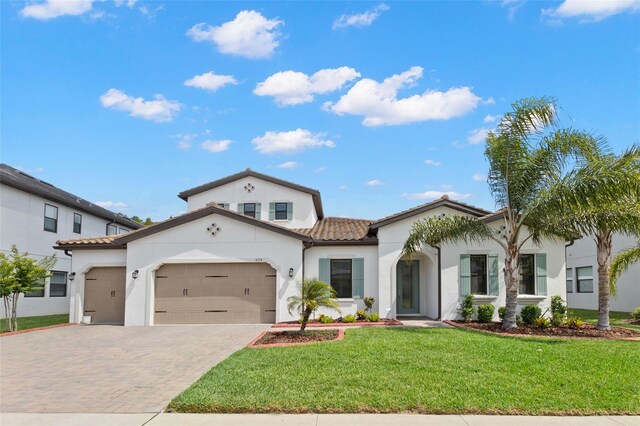 6154 Marsh Trail Dr, Odessa, FL 33556 - mediterranean / spanish home featuring a tiled roof, a garage, driveway, stucco siding, and a front yard