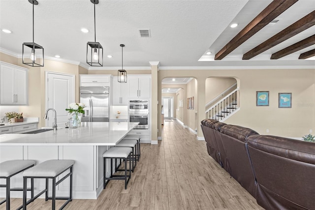 6154 Marsh Trail Dr, Odessa, FL 33556 - kitchen featuring appliances with stainless steel finishes, arched walkways, open floor plan, a breakfast bar, and a sink