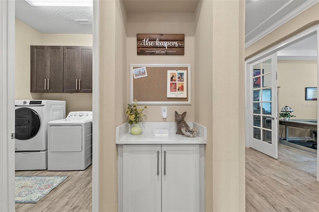 6154 Marsh Trail Dr, Odessa, FL 33556 - washroom with washing machine and dryer, light wood-style flooring, and cabinet space