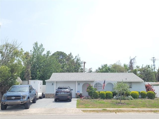 ranch-style home featuring a garage, concrete driveway, and stucco siding