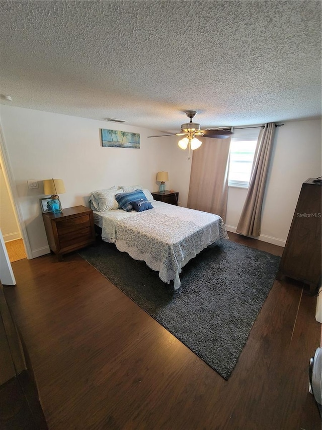 bedroom with wood finished floors, a textured ceiling, ceiling fan, and baseboards