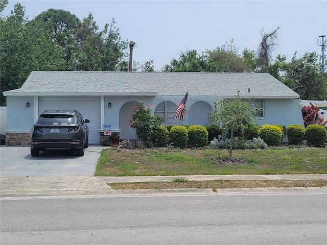 ranch-style house featuring an attached garage, concrete driveway, and stucco siding