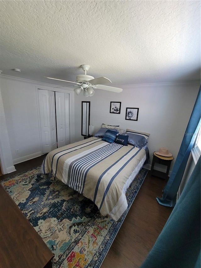 bedroom with a ceiling fan, a closet, wood finished floors, a textured ceiling, and ornamental molding